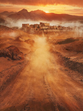 Dirt desert road leading to a ancient city civilization. Vibrant sunset sky. Fictional middle eastern biblical city castle ruins. Arid dry landscape with mountains. Cities such as: Nazareth, Capernaum