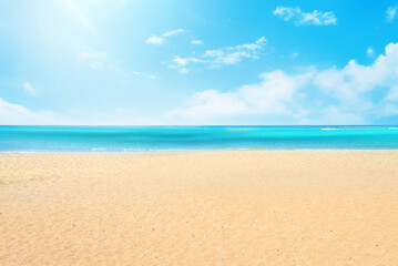 Empty natural beach background with golden sand and blue sky with white clouds on a hot summer sunny day.