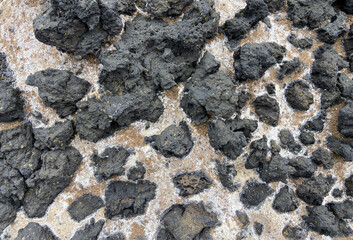 The texture of a frozen volcanic lava.Stone with a non-uniform surface.Magma rock background close...