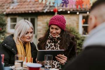 Friends looking at a tablet at a birthday party