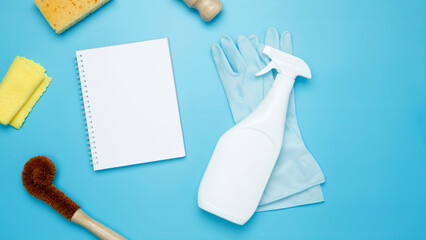 Various accessories cleaning products, sprays, rags, sponges and brushes. Mock up white notebook. Top view, flat lay, copy space