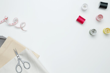 Composition with various threads and sewing accessories on white background. Top view, copy space