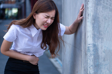 Sick asian woman suffering from stomach ache, concept of menstrual period cramp, abdominal pain,...