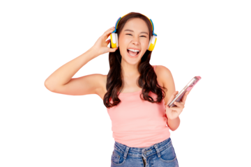 Happy young asian woman laughing while listening to music on yellow wireless headphones and holding a smartphone, PNG