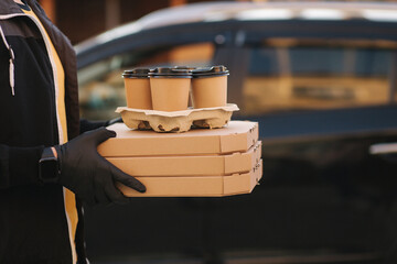 Courier holds order. Man from delivery service bring pizza and coffee. Place for text