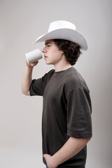young man in profile with coffee cup and cowboy hat