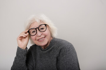older gray-haired woman smiling at the camera wearing glasses