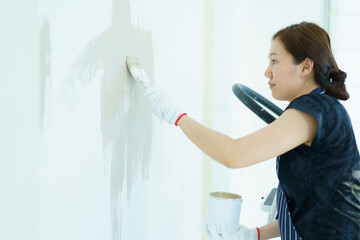 Woman painting the wall by herself.
