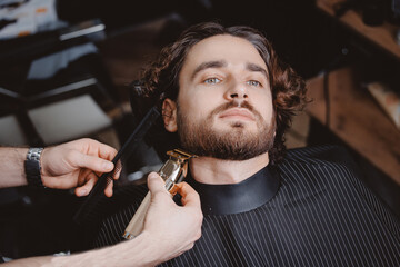 Man hipster having barber shave barbershop hair machine