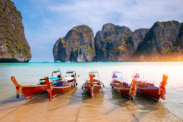 Maya Bay island Phi Phi Leh with longtail boat, turquoise clear water in Krabi Thailand. Amazing travel landscape photo in Thai