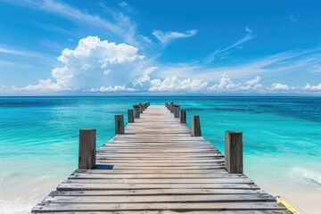Wooden pier stretching into azure water on beach, merging with horizon