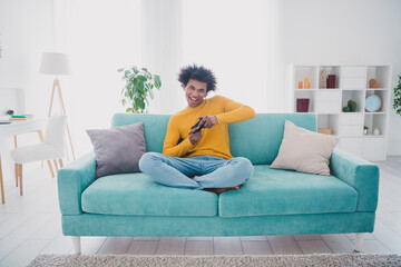 Obraz premium Full size photo of nice young man play games couch wear yellow pullover white interior apartment indoors