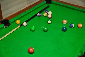 Cue and balls on a billiard table, playing “eight-ball,” billiards game, pause during a billiards game, unfinished game