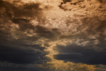 Sunlight piercing through dark heavy clouds, dramatic sky, pre-storm sky, ominous sky