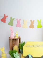 a group of easter bunnies hanging on a rope figurines of rabbits on the floor