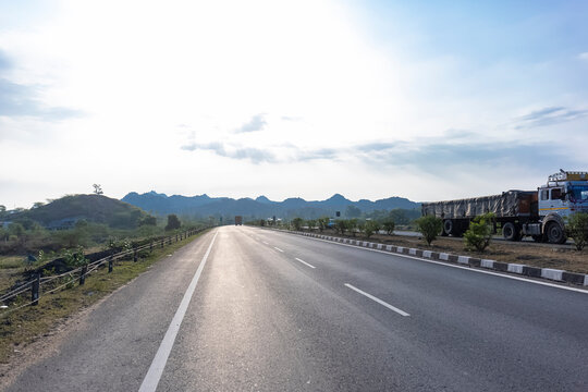 Landscape of Indian national highways surrounded by aravalli hills under the blue sky. National highways connected different cities and also saves time and fuel.