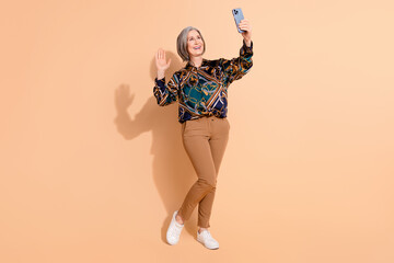 Fill size photo of good mood retired woman dressed print shirt waving hand say hi on smartphone...