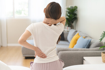 Pain body muscles stiff problem, asian young woman painful back, neck ache from work hand holding massaging rubbing shoulder hurt, sore sitting on bed while wake up at home. Health care and medicine.