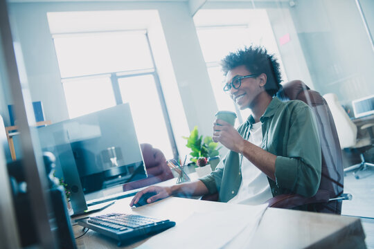 Photo of clever intelligent manager wear khaki shirt glasses enjyoing coffee chatting modern device indoors workshop workplace