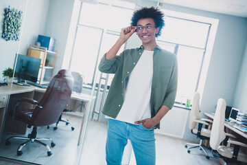Photo of cool smart employee wear khaki shirt hanf arm eyeglasses smiling indoors workstation...