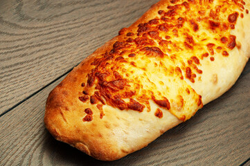 pita bread with cheese on a wooden background. pastries covered with cheese on a brown background	