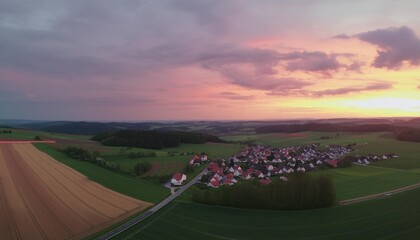 aerial panorama of a vast landscape with a small town at a gorgeous colorful sunset with dramatic...