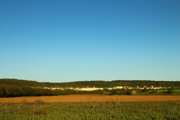 Obraz premium A field with a blue sky and clouds