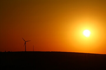 Obraz premium A sunset with a few wind turbines