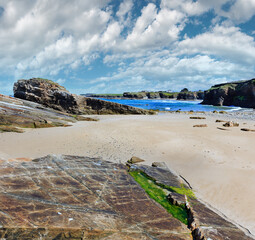 Summer Atlantic coast landscape with beach and rock formations (Praia Das Illas, Spain).