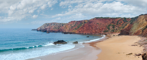 Amado Beach cloudy summer view with colorful cliffs, Algarve, Portugal. Three shots stitch panorama. 
