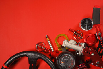 Sport car tuning equipment and spare parts on red top view background with copy space. Motorsport concept background.