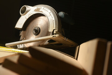 Circular saw and wooden boards close up background. Front view. Woodwork.