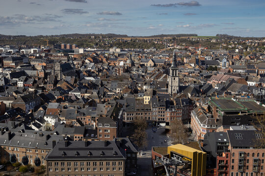 Panoramic cityscape of Namur in Wallonia, Belgium. Captured here on a spring day with a mix of modern and traditional architecture set against a blue sky with scattered clouds. Copyspace above.