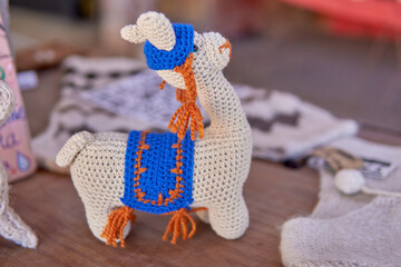 handmade souvenir crocheted knitted doll of a small white llama. decoration, horizontal