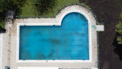 zenithal view of a swimming pool in winter preparing for summer. pool not yet cleaned. pool ground. blue water.
