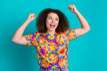 Photo of glad cheerful lovely girl wear trendy vibrant print clothes look empty space isolated on cyan color background