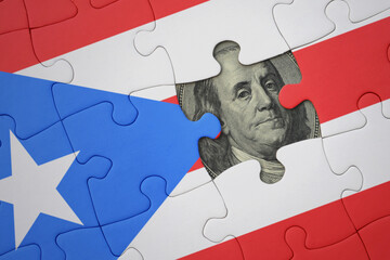 puzzle with the national flag of puerto rico and usa dollar banknote. finance concept