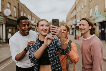 Fototapeta na wymiar Happy diverse friends taking selfies in the city