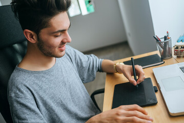 Close up of young boy using graphic tablet