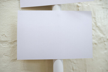 An empty blank paper table card name plate sign on a wall, empty note, shot with a shallow depth of...