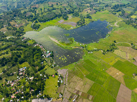 Lake Seloton with fish farm surrounded by agricultural landscape. Mountain with green forest. Lake Sebu. Mindanao, Philippines.