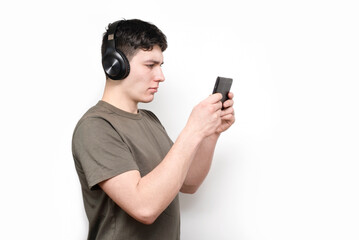Boy college student in wireless headphones looking at tablet in concentration and taking online class in college, he has temporary online training