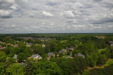 Aerial panoramic view of an upscale suburb and lush green landscape in USA shot during early spring of 2024