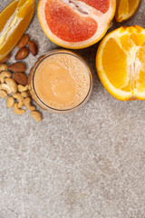 Fruit nut smoothie in a glass on a stone background, copy space for text