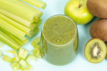 Green smoothie of celery, kiwi, green apple and spinach in a glass