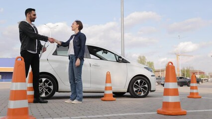 Beginning of practical driving lessons. Arabic man as instructor and Caucasian woman as student. Driving school or driving course concept