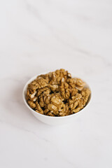 Walnut in a white bowl on a marble table
