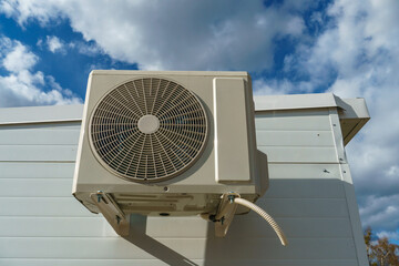 Outdoor air conditioning unit. A large modern air conditioner on the wall of an apartment building....