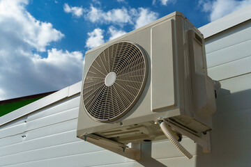 Outdoor air conditioning unit. A large modern air conditioner on the wall of an apartment building....