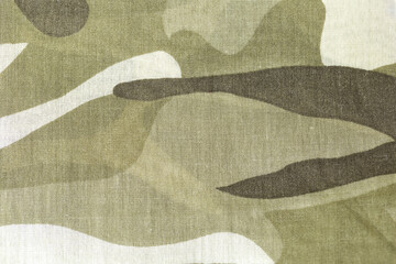 A close up of a piece of camouflage fabric. The fabric is a mix of brown and white, with a pattern...